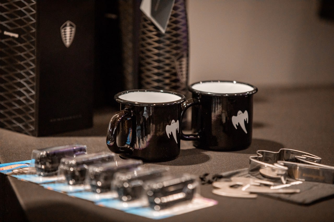 Detaljbild: muggar och merchandise på bord under eventet.