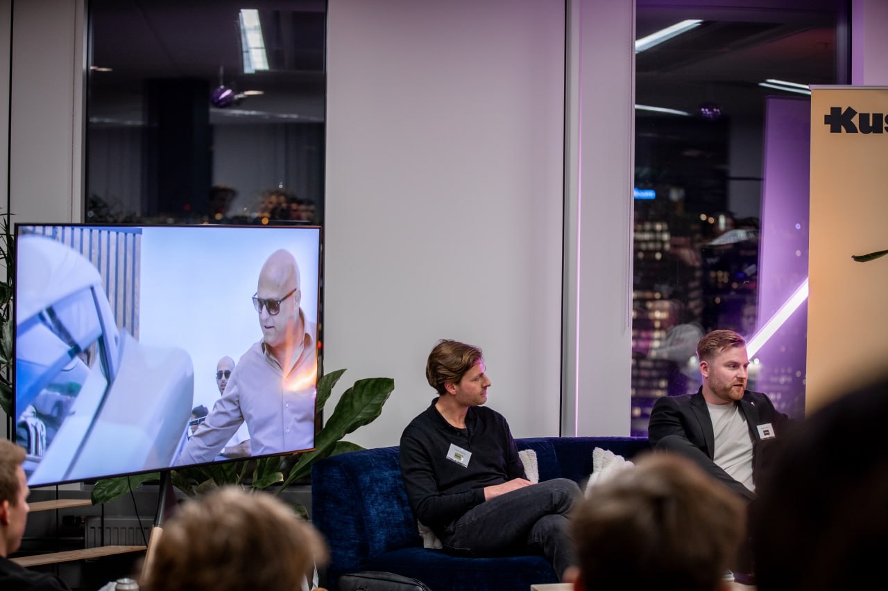 Panelsamtal i soffan med publik och skärm bredvid.