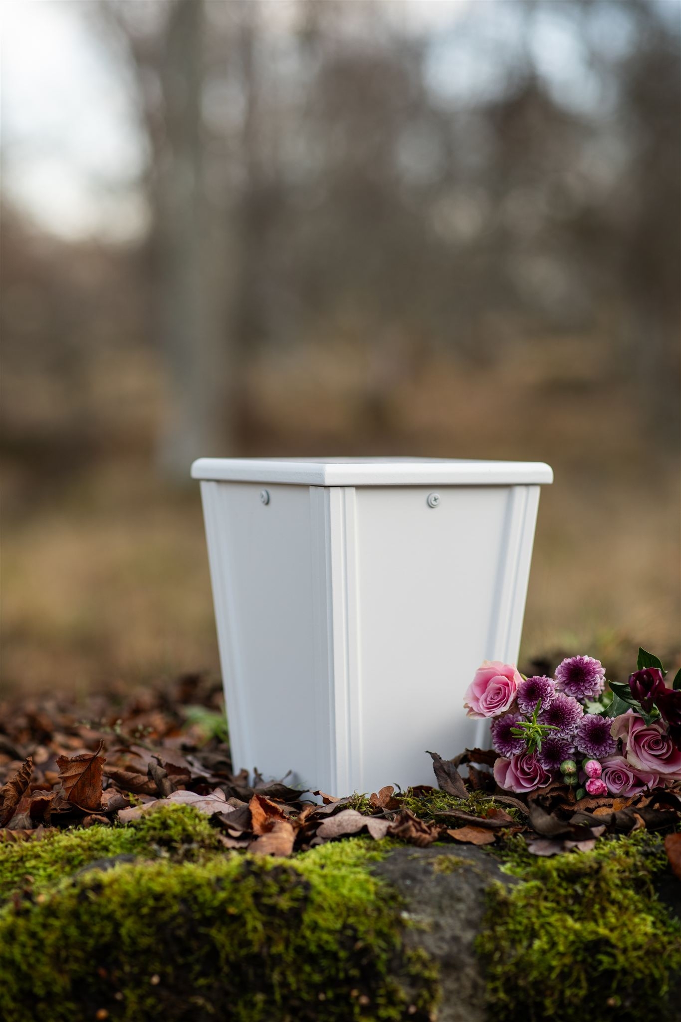 Minventa – vit urna för djur med blomsterbukett